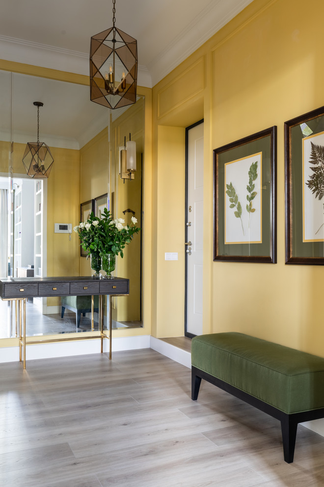 Idee per una porta d'ingresso classica di medie dimensioni con pareti gialle, pavimento in laminato, una porta singola, una porta bianca e pavimento beige
