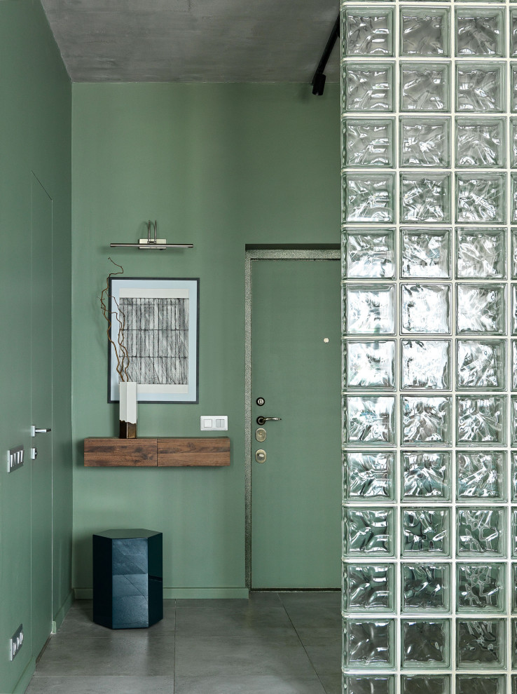 Diseño de hall contemporáneo pequeño con paredes verdes, suelo de baldosas de porcelana, puerta simple, puerta verde y suelo gris