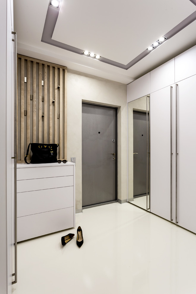 Idée de décoration pour une porte d'entrée design avec un mur beige, une porte simple, une porte grise, un sol blanc et sol en béton ciré.