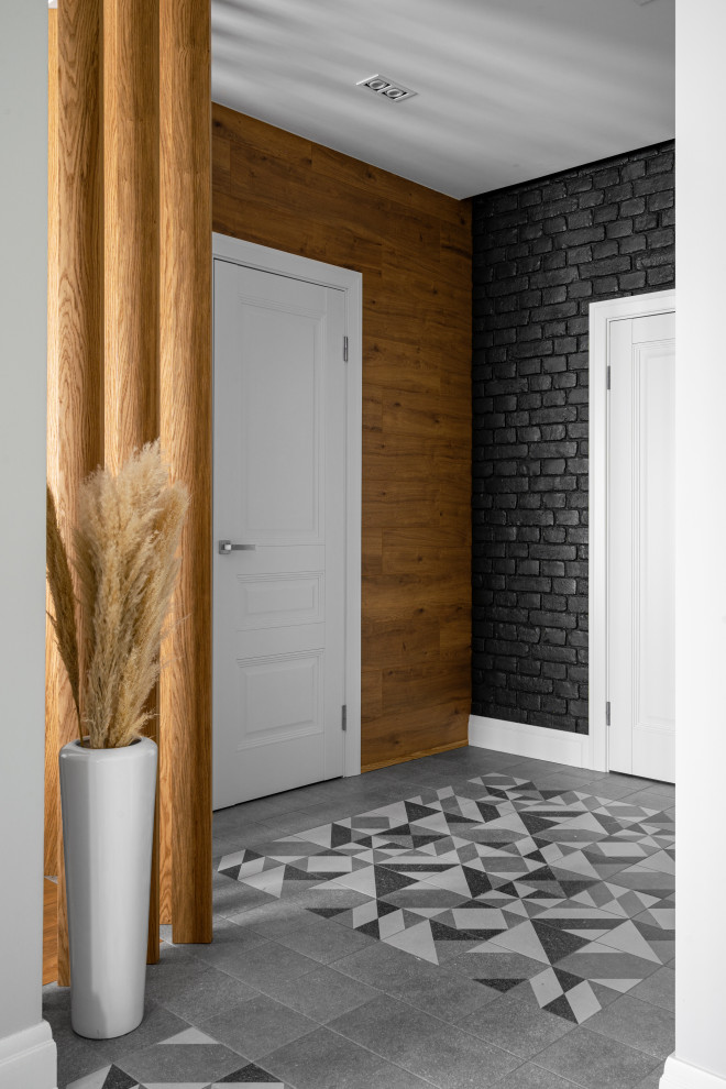 Modelo de puerta principal actual de tamaño medio con paredes negras, suelo de baldosas de porcelana, puerta simple, puerta blanca, suelo gris y ladrillo