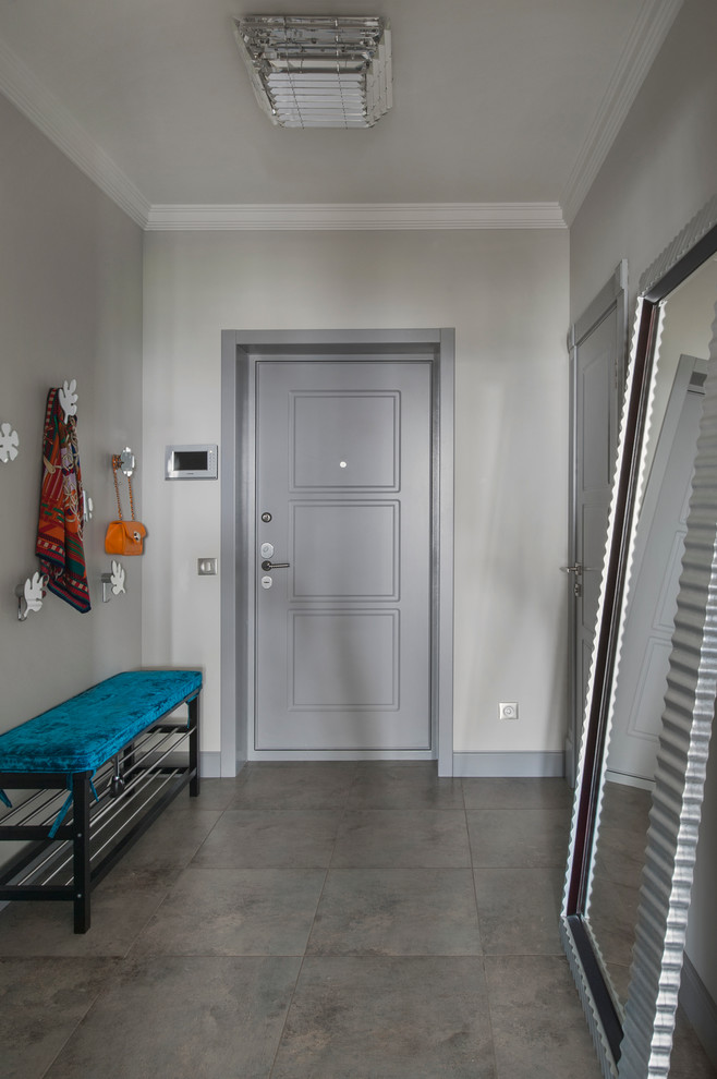 Exemple d'une porte d'entrée tendance avec un mur gris, une porte simple et une porte grise.