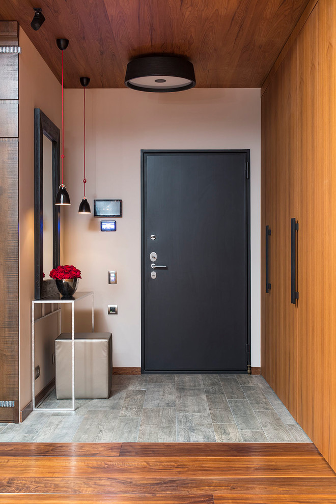 Идея дизайна: входная дверь в современном стиле с белыми стенами, одностворчатой входной дверью и черной входной дверью