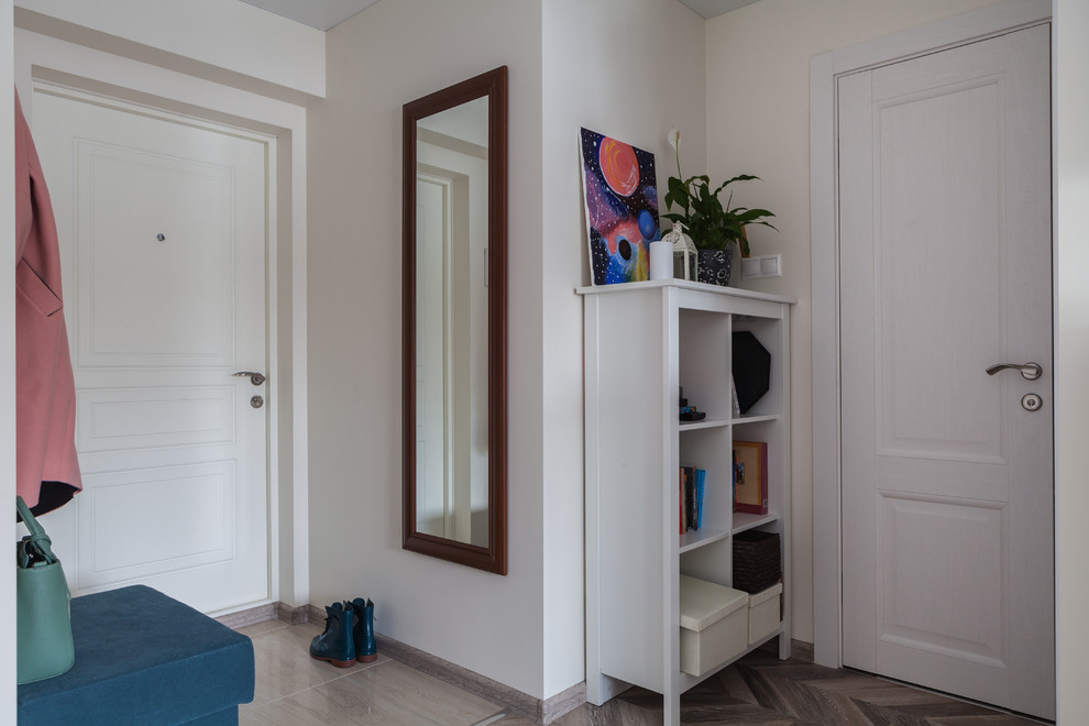 Ejemplo de puerta principal actual pequeña con paredes beige, suelo laminado, suelo marrón, puerta simple y puerta blanca
