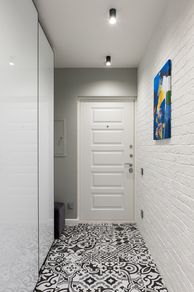 Esempio di un corridoio minimal di medie dimensioni con pareti bianche, pavimento con piastrelle in ceramica, una porta singola, una porta bianca e pavimento multicolore
