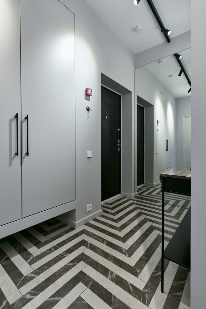Idee per un ingresso o corridoio contemporaneo di medie dimensioni con pareti bianche, pavimento in gres porcellanato, una porta singola, una porta nera e pavimento multicolore