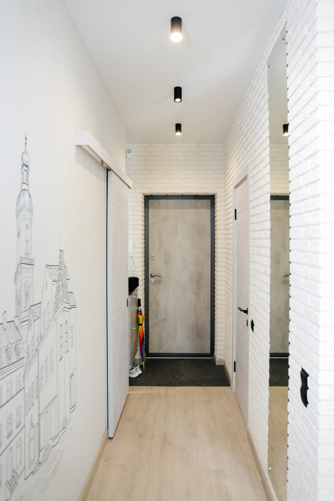Entryway - small contemporary laminate floor, gray floor and brick wall entryway idea in Other with gray walls and a gray front door