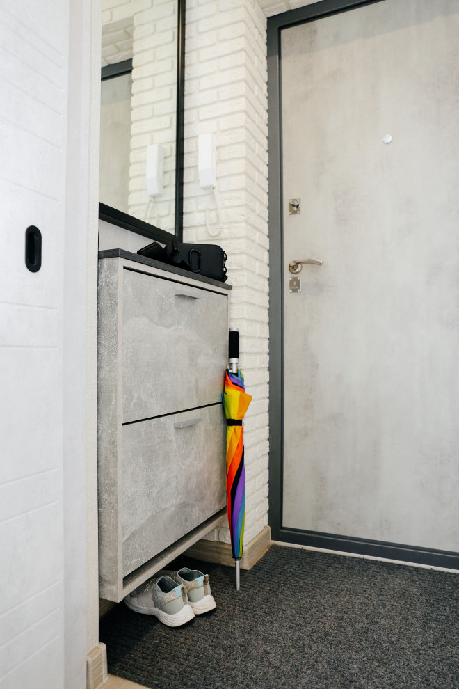 Small trendy laminate floor, gray floor and brick wall entryway photo in Other with gray walls and a gray front door