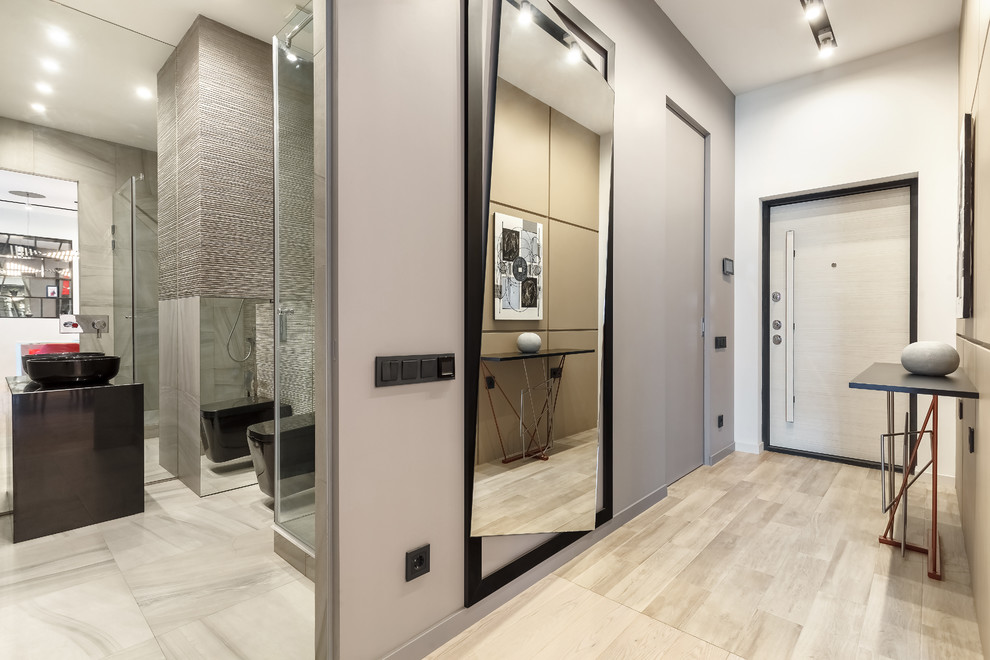 This is an example of a small contemporary hallway in Moscow with beige walls, laminate floors, a pivot front door, a white front door and beige floors.