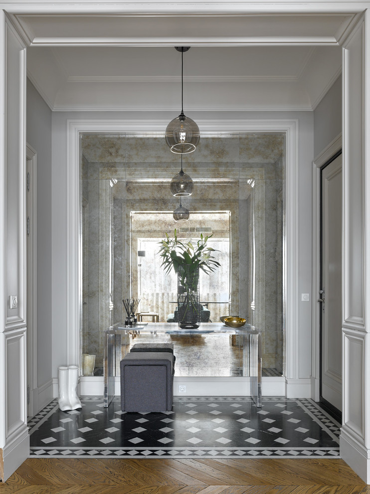 Стильный дизайн: тамбур в стиле неоклассика (современная классика) с серыми стенами, одностворчатой входной дверью, белой входной дверью и черным полом - последний тренд