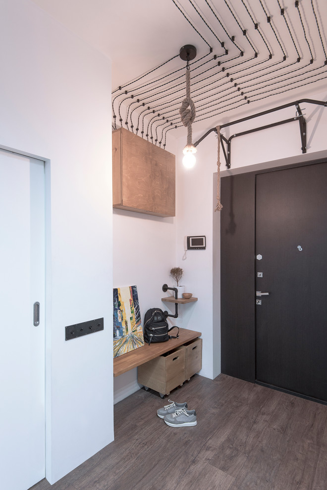 This is an example of a medium sized urban front door in Moscow with white walls, laminate floors, a double front door, a black front door and brown floors.