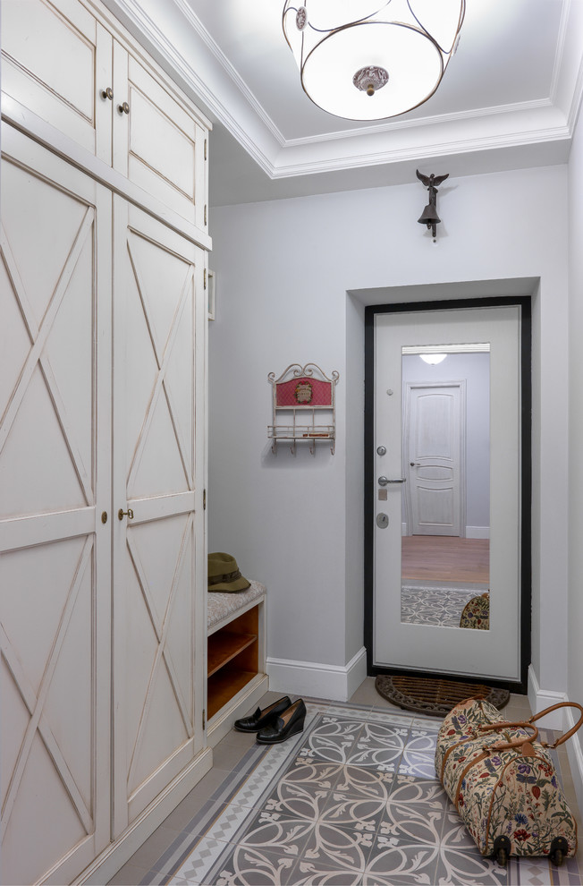 Стильный дизайн: тамбур в классическом стиле с одностворчатой входной дверью, белой входной дверью и серыми стенами - последний тренд
