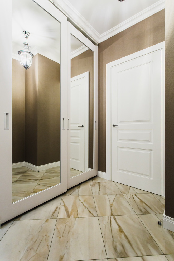 На фото: прихожая среднего размера в современном стиле с коричневыми стенами, полом из керамогранита, одностворчатой входной дверью и белой входной дверью с
