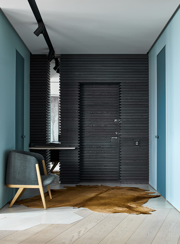 Diseño de puerta principal contemporánea con paredes azules, suelo de madera clara, puerta simple y puerta negra