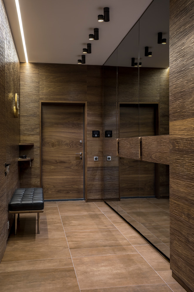Свежая идея для дизайна: входная дверь среднего размера в современном стиле с коричневыми стенами, полом из керамогранита, одностворчатой входной дверью, входной дверью из дерева среднего тона и коричневым полом - отличное фото интерьера