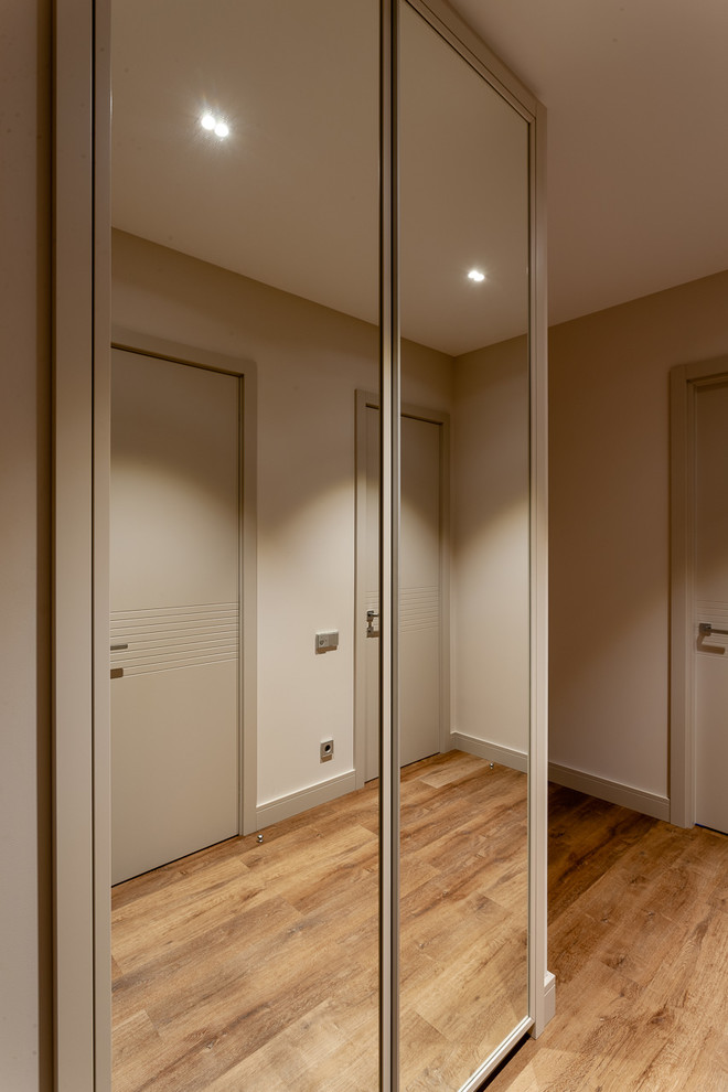 Foto de puerta principal contemporánea de tamaño medio con paredes grises, suelo vinílico, puerta simple, puerta gris y suelo marrón