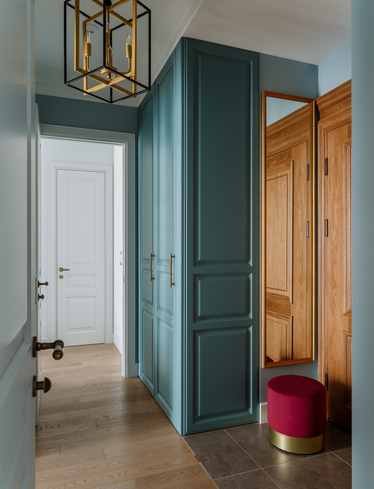 モスクワにあるお手頃価格の小さなトラディショナルスタイルのおしゃれな玄関ドア (青い壁、無垢フローリング、木目調のドア、茶色い床) の写真