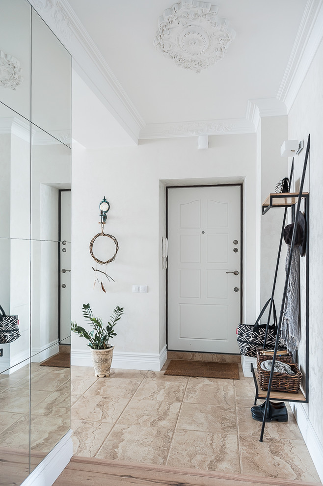 Eklektisk inredning av en ingång och ytterdörr, med vita väggar, en enkeldörr, en vit dörr och beiget golv