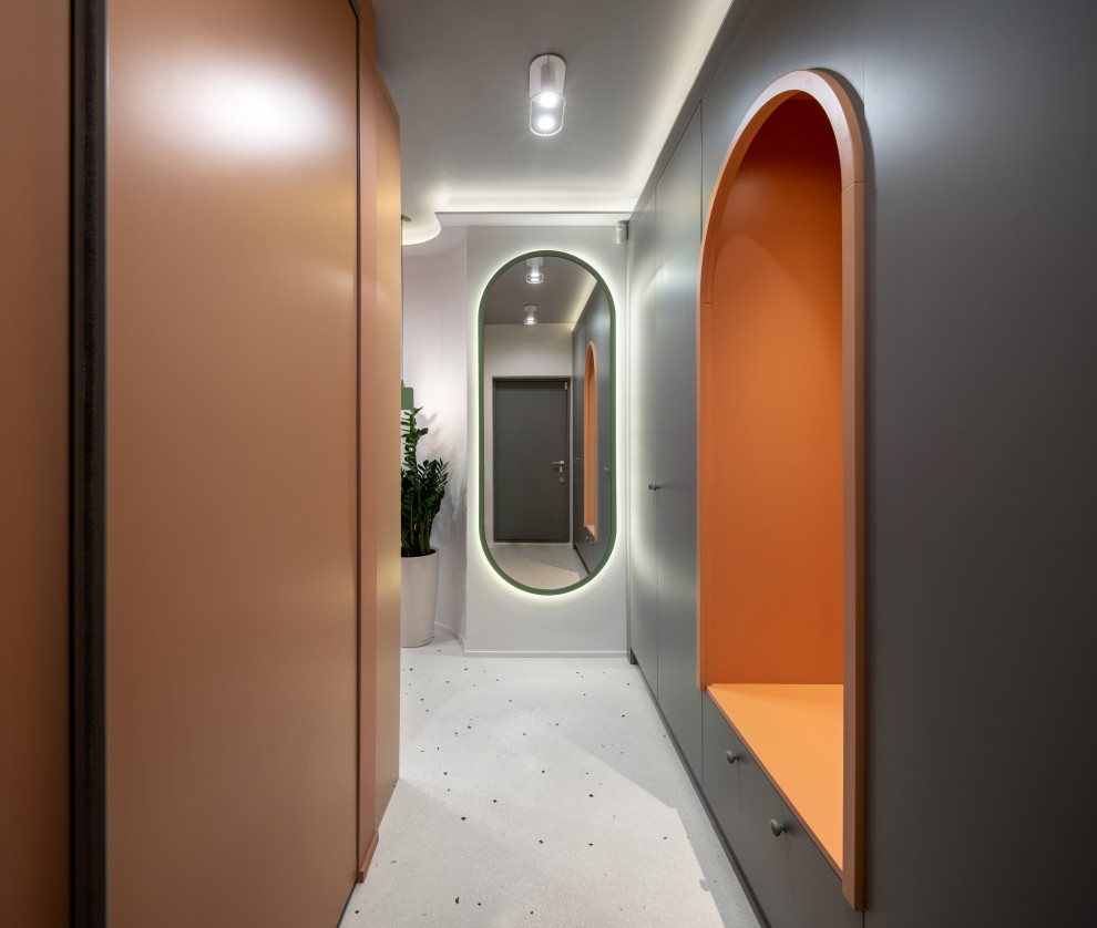 Aménagement d'une grande entrée contemporaine avec un couloir, un mur orange, un sol en terrazzo et un sol blanc.
