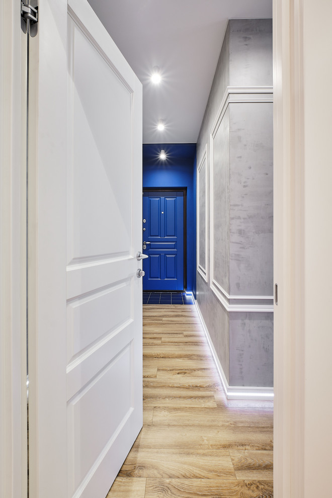 Пример оригинального дизайна: маленькая входная дверь в стиле лофт с серыми стенами, полом из ламината, одностворчатой входной дверью, синей входной дверью и бежевым полом для на участке и в саду