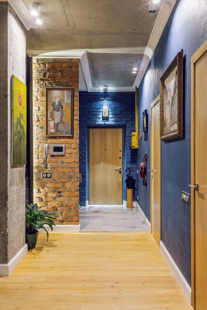 Esempio di una porta d'ingresso industriale con pareti blu, una porta singola e una porta in legno bruno