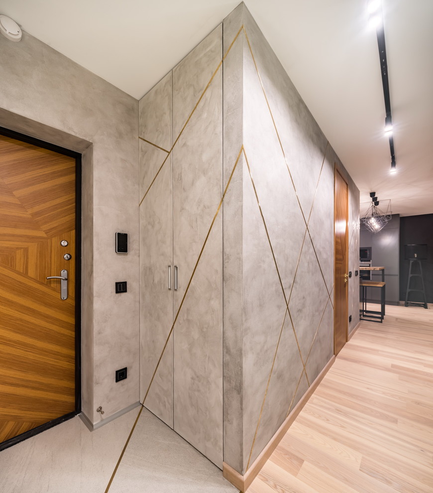 Imagen de puerta principal actual con paredes grises, puerta simple, puerta de madera en tonos medios, suelo de madera clara y suelo beige