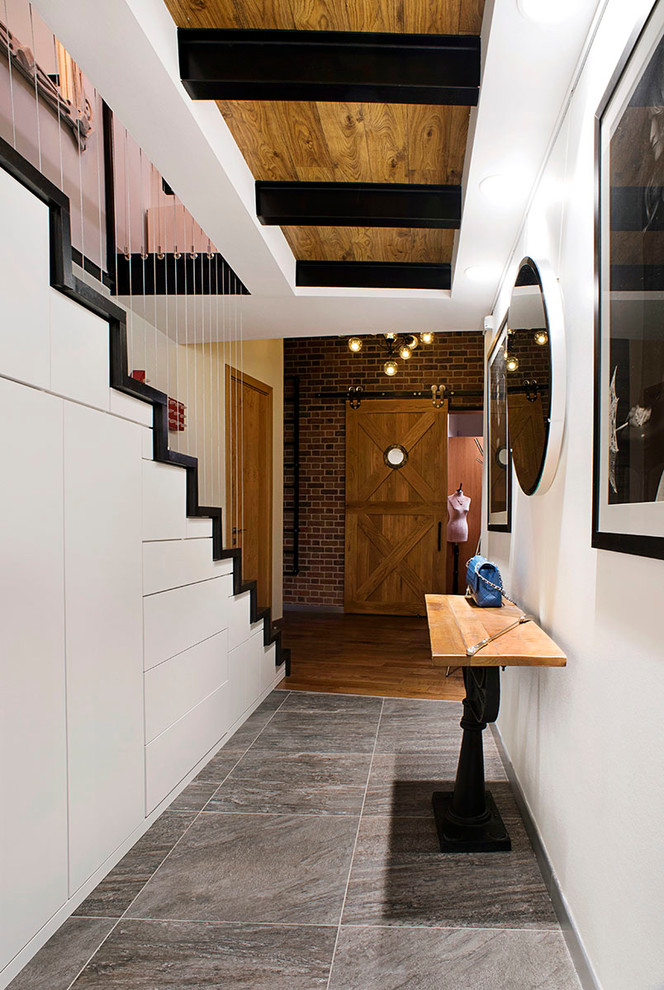 Foto på en funkis entré, med vita väggar och grått golv