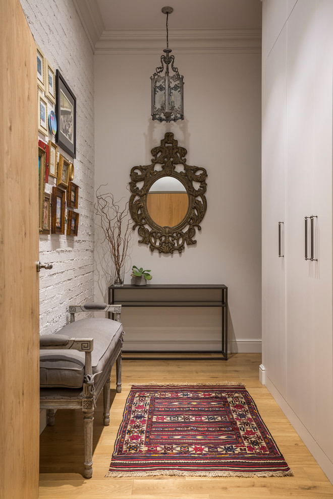 Immagine di un ingresso o corridoio chic con pareti bianche, pavimento in legno massello medio e pavimento marrone