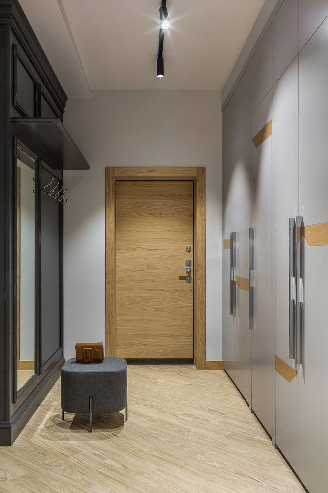 Идея дизайна: узкая прихожая среднего размера в современном стиле с серыми стенами, полом из винила, одностворчатой входной дверью, входной дверью из дерева среднего тона и желтым полом