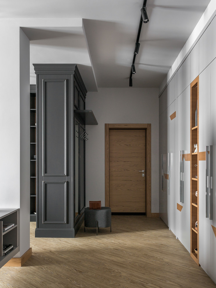Cette image montre une entrée design de taille moyenne avec un couloir, un mur gris, un sol en vinyl, une porte simple, une porte en bois brun et un sol jaune.