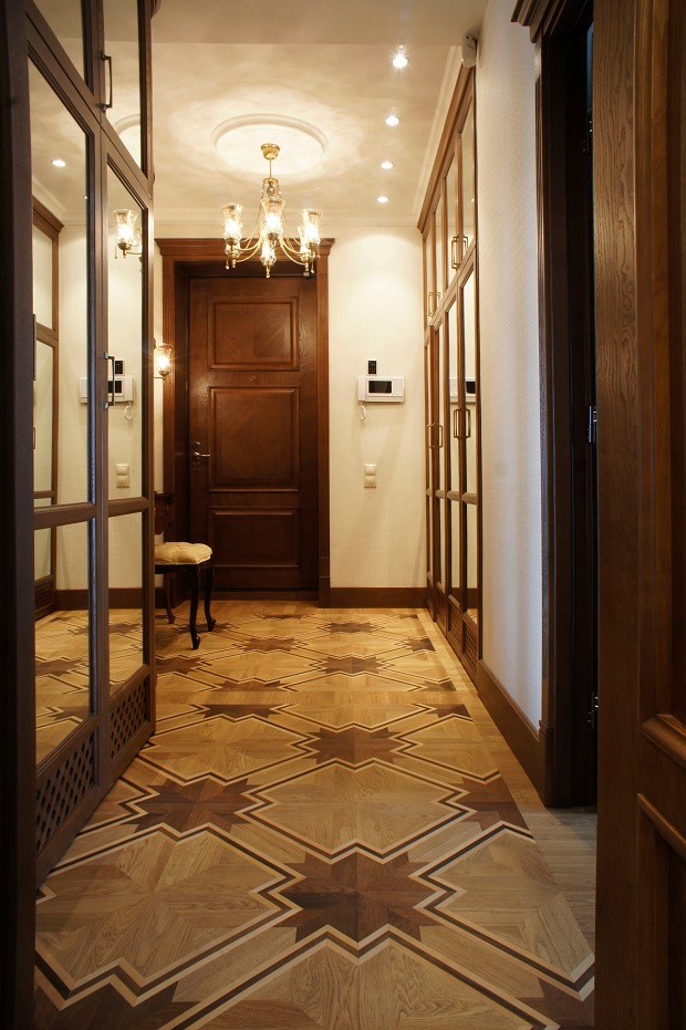 Immagine di un piccolo corridoio classico con pareti beige, pavimento in legno massello medio, una porta singola, una porta in legno bruno e pavimento marrone