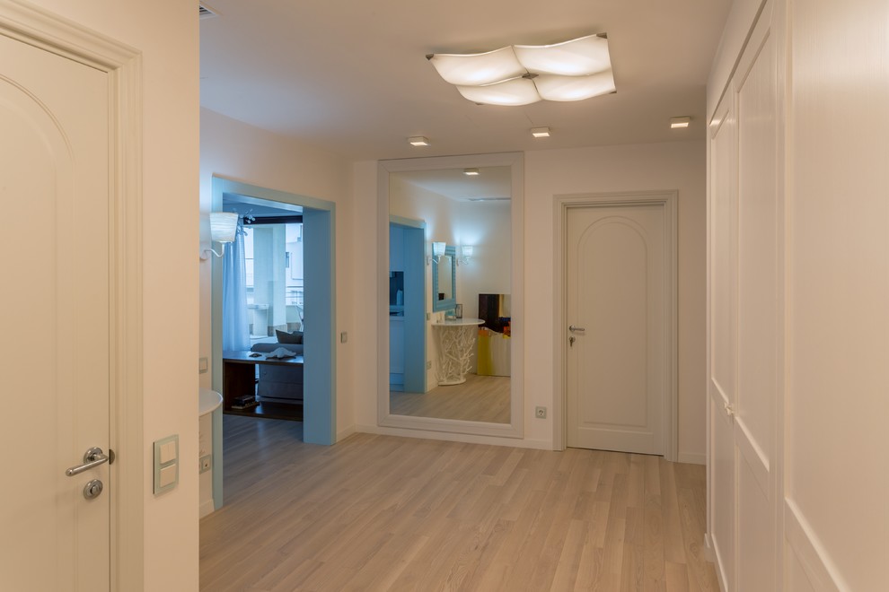 Mediterrane Haustür mit weißer Wandfarbe, hellem Holzboden, Einzeltür, weißer Haustür und braunem Boden in Sonstige