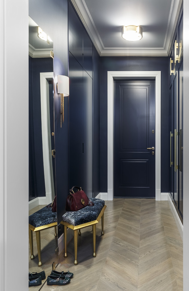 Idées déco pour une porte d'entrée contemporaine avec un mur bleu, parquet clair, une porte simple, une porte bleue et un sol beige.