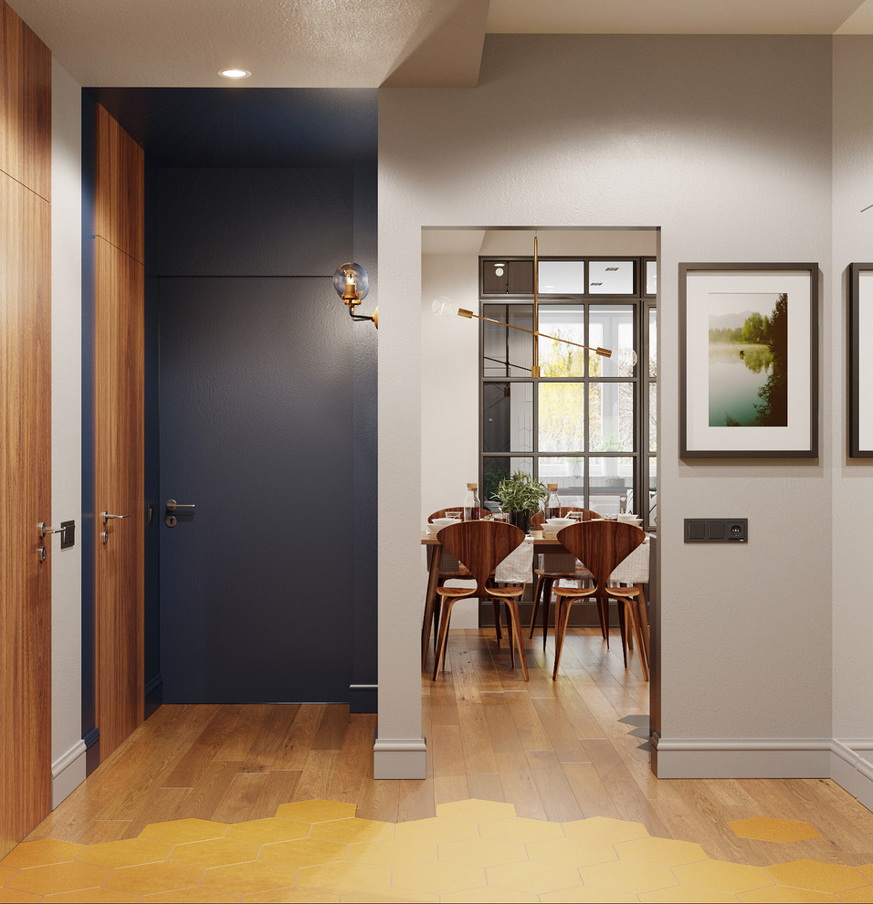 На фото: узкая прихожая среднего размера в современном стиле с серыми стенами, одностворчатой входной дверью, серой входной дверью, паркетным полом среднего тона и коричневым полом с