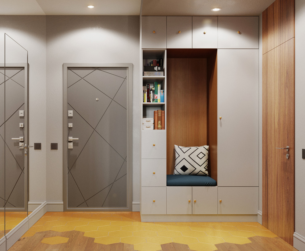Réalisation d'une entrée design de taille moyenne avec un mur gris, une porte simple, une porte grise, un couloir, un sol en bois brun et un sol marron.