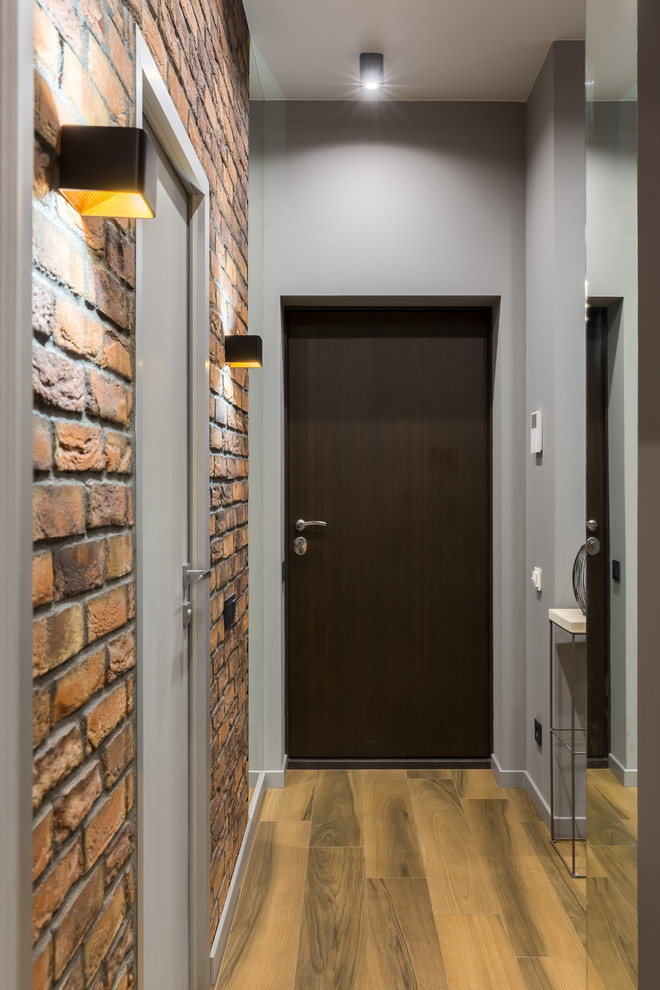 На фото: маленькая входная дверь в современном стиле с серыми стенами, полом из керамогранита, одностворчатой входной дверью, коричневой входной дверью и коричневым полом для на участке и в саду