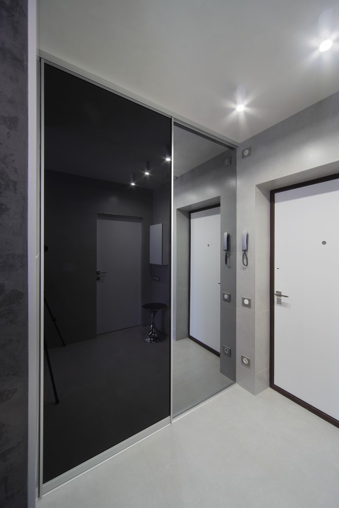 Idée de décoration pour une porte d'entrée design de taille moyenne avec un mur gris, une porte simple et une porte blanche.