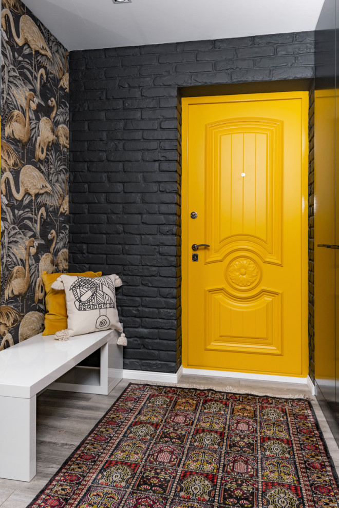 Exempel på en mellanstor modern hall, med svarta väggar, en enkeldörr, en gul dörr och grått golv