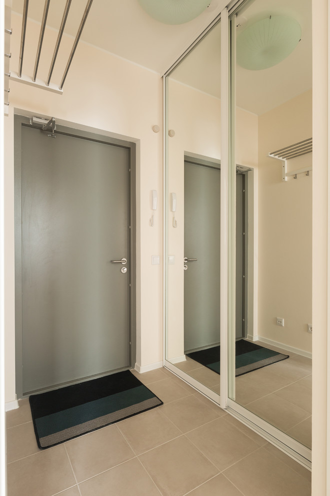 Idee per un corridoio nordico di medie dimensioni con pareti beige, pavimento in gres porcellanato, una porta singola, una porta grigia e pavimento beige