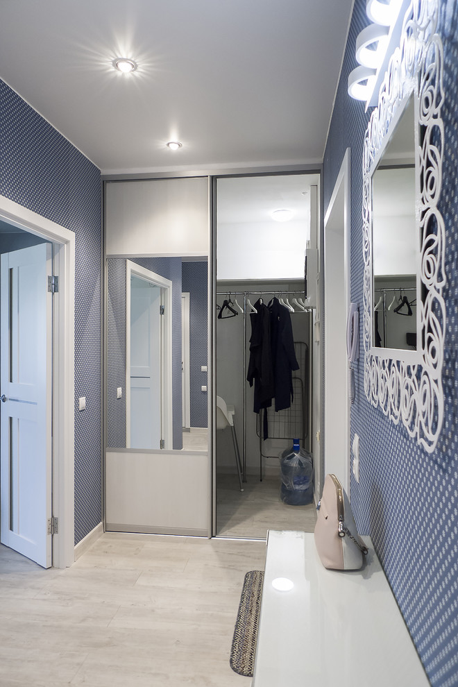 This is an example of a medium sized contemporary front door in Saint Petersburg with blue walls, vinyl flooring, a pivot front door, a white front door, grey floors and wallpapered walls.