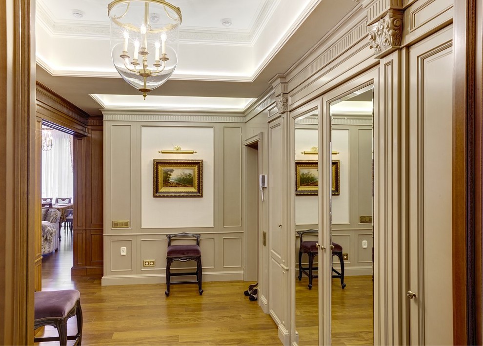 Foto di un ingresso o corridoio classico con pavimento in legno massello medio e pareti beige