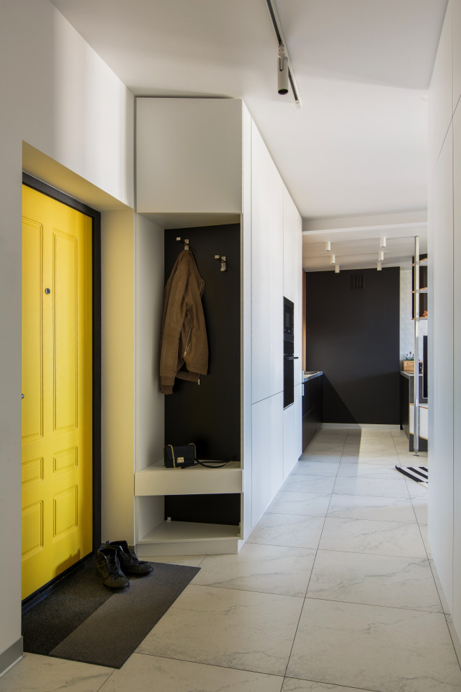 Cette image montre une porte d'entrée design avec un mur blanc, une porte simple, une porte jaune et un sol blanc.