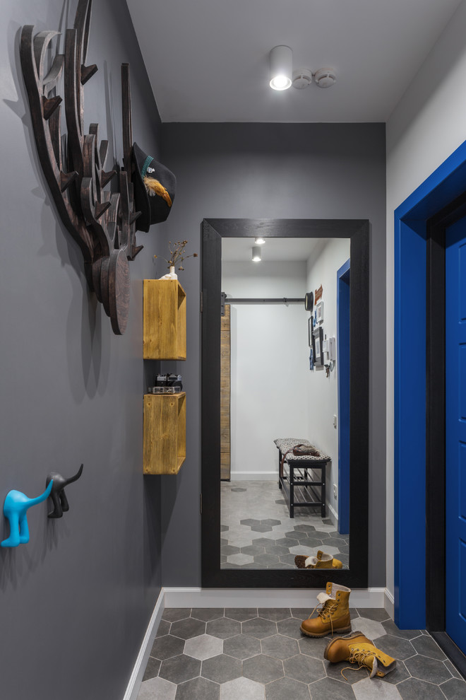 Exempel på en liten minimalistisk ingång och ytterdörr, med grå väggar, klinkergolv i porslin, en enkeldörr, en blå dörr och grått golv