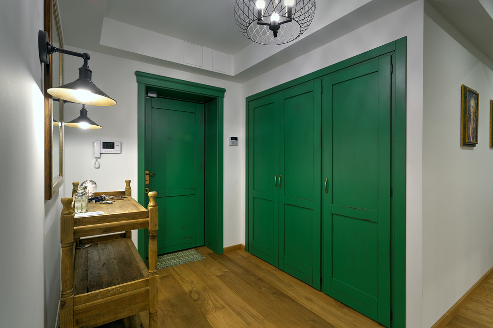 На фото: входная дверь среднего размера в современном стиле с белыми стенами, паркетным полом среднего тона, одностворчатой входной дверью и зеленой входной дверью с