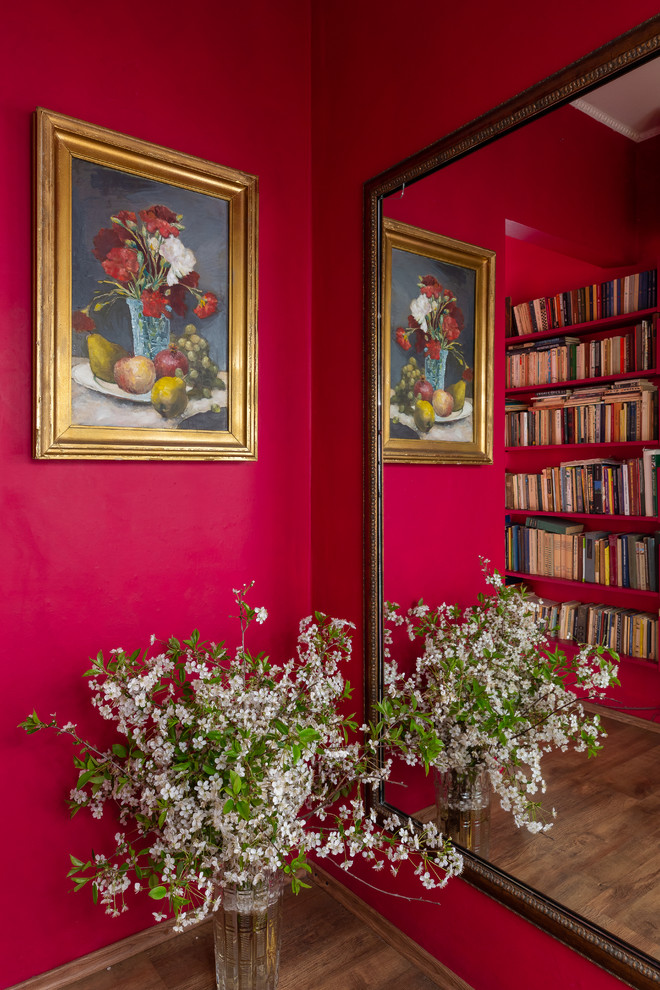 Cette photo montre une entrée éclectique de taille moyenne avec un couloir, un mur rose et un sol en bois brun.