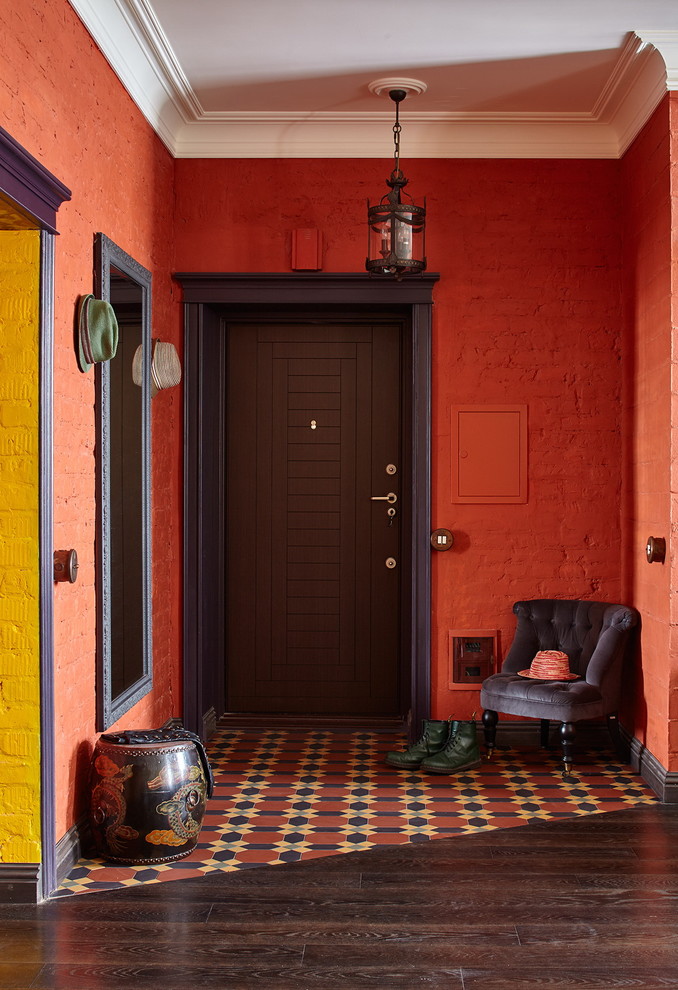 Пример оригинального дизайна: фойе среднего размера в стиле фьюжн с красными стенами, полом из керамической плитки, одностворчатой входной дверью, входной дверью из темного дерева и разноцветным полом