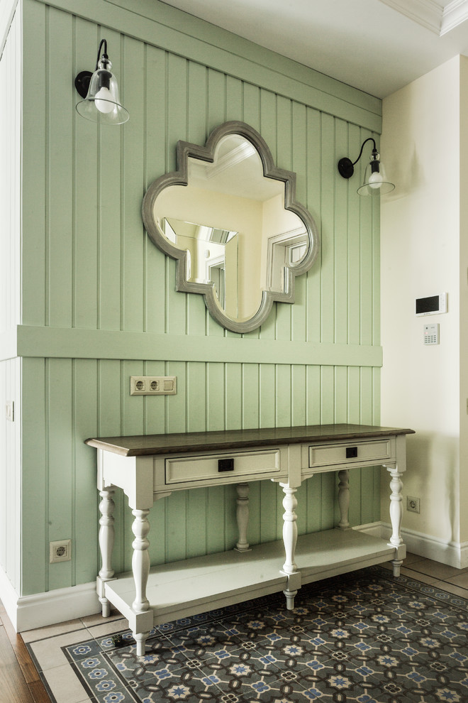 На фото: прихожая среднего размера в стиле неоклассика (современная классика) с зелеными стенами, полом из керамической плитки и зеленым полом с