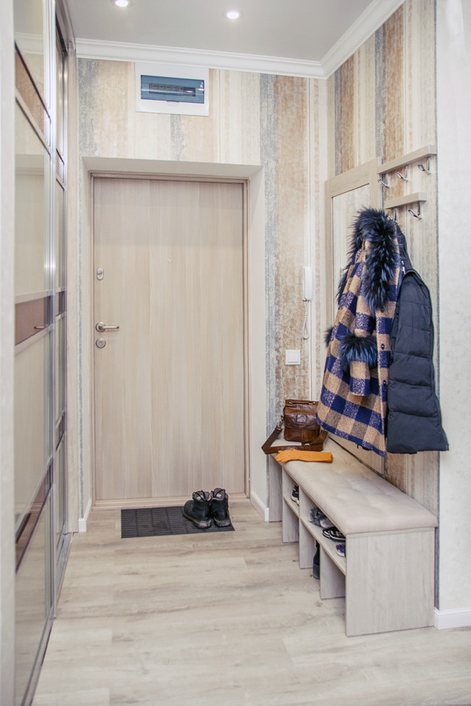ノボシビルスクにあるお手頃価格の小さなトランジショナルスタイルのおしゃれな玄関ドア (マルチカラーの壁、ラミネートの床、淡色木目調のドア、ベージュの床) の写真