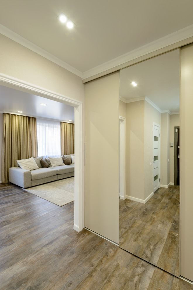 Exemple d'une entrée tendance de taille moyenne avec un couloir, un mur beige, un sol en vinyl, une porte simple, une porte marron et un sol marron.