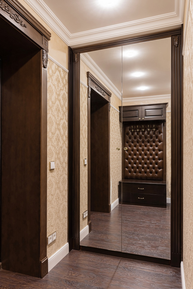 Ejemplo de hall clásico pequeño con paredes beige, suelo laminado, puerta simple, puerta marrón y suelo marrón
