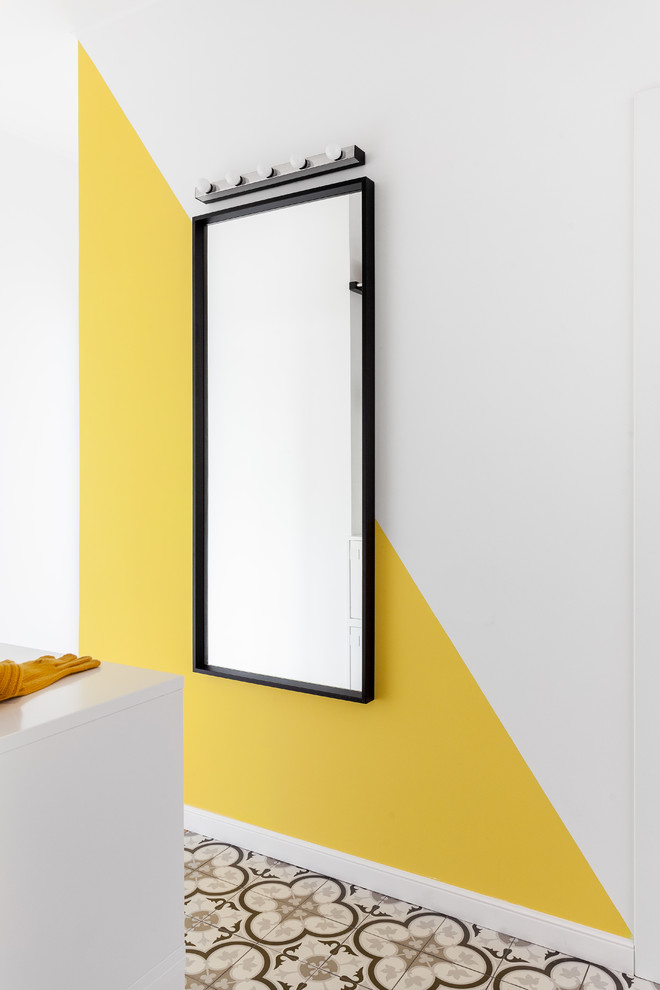 Bild på en minimalistisk hall, med vita väggar, klinkergolv i keramik, en enkeldörr, en svart dörr och grått golv